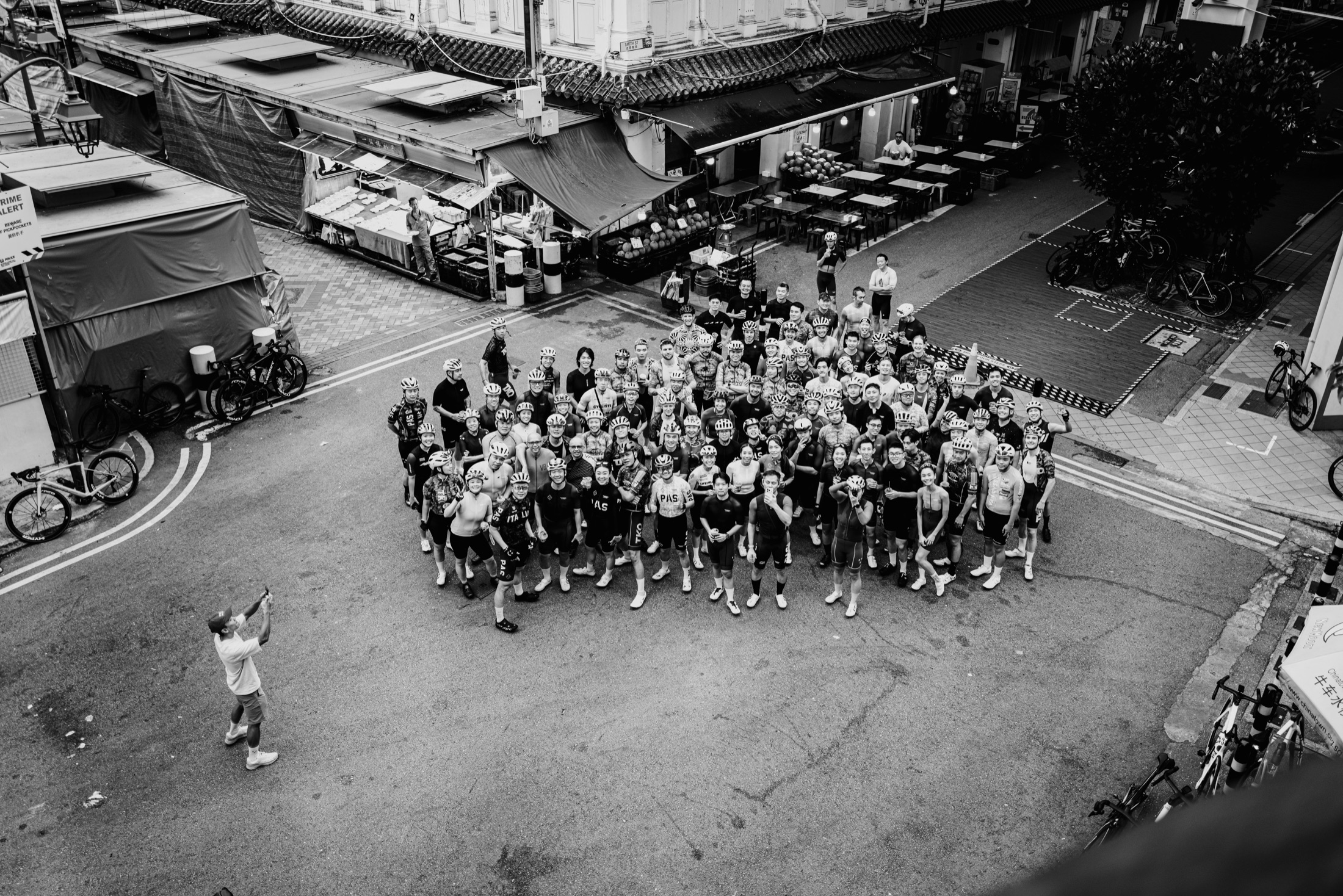 A cycling community gathered for a black and white group portrait