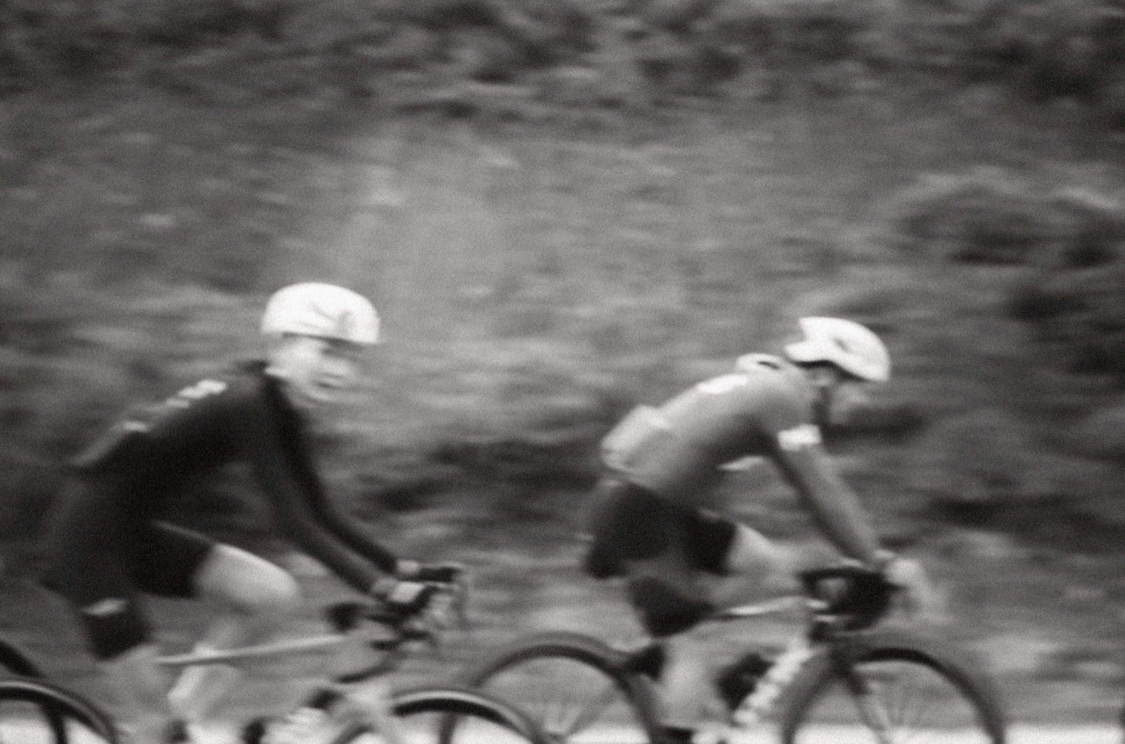 Cyclists captured in motion in a black and white photograph