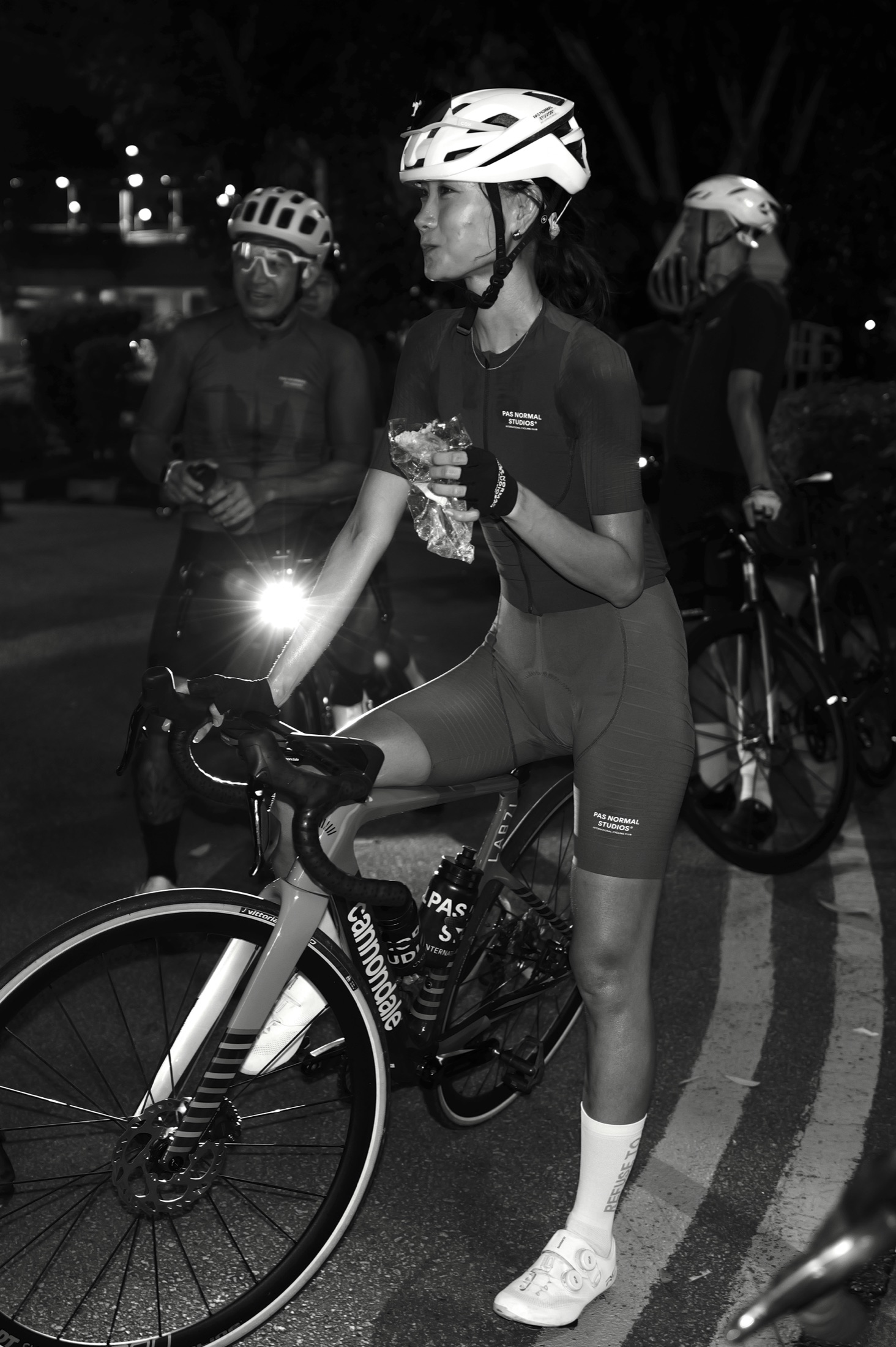 Diem pausing with her bike during a night group ride